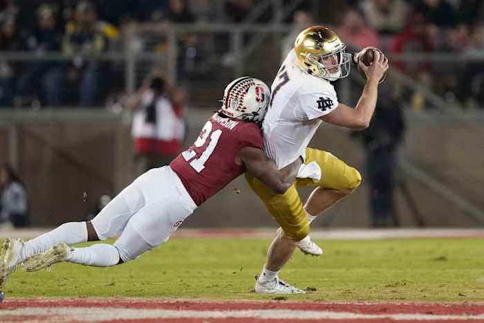 Stanford, California, USA; Stanford Cardinal safety Kendall Williamson (21) tackles Notre Dame Fighting Irish quarterback Jack Coan (17) during the first quarter at Stanford Stadium.